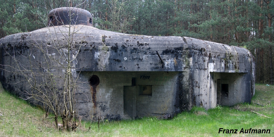 Fot. 04 Schron do ognia jednobocznego odcinka "Nowogród". Na zdjęciu dwie strzelnice obrony bezpośredniej. Pierwsza od lewej ma bronic podejścia do strzelnicy głównej ckm. Druga broni wejścia do schronu.